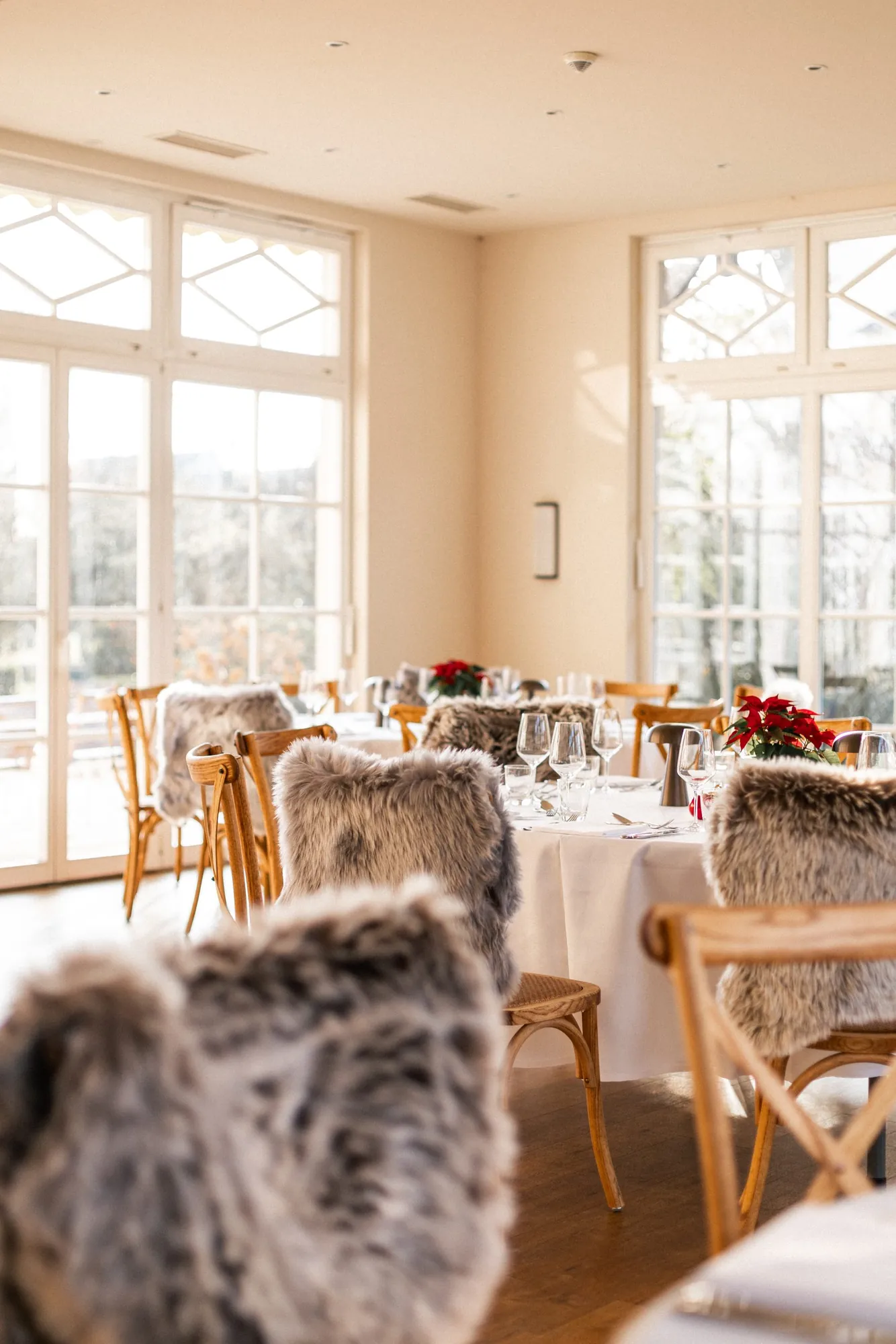 Restaurant im Winter mit fellbezogenen Stühlen und gedeckten Tischen