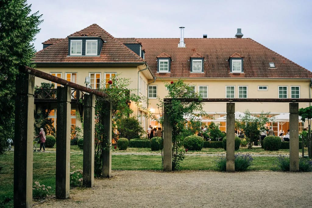 Holzpergola im Schlossgarten mit dem Schlosshotel im Hintergrund