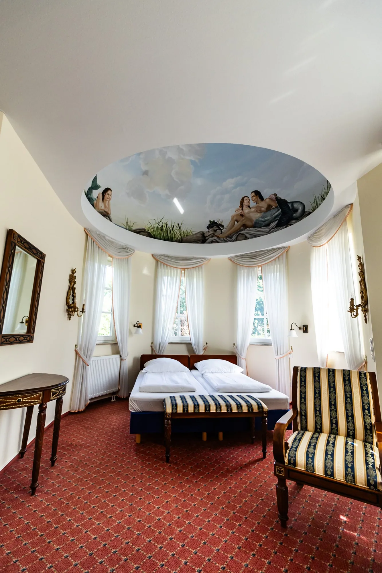 Engelssuite mit Deckengemälde, Doppelbett, Erkerfenstern und rotem Teppich