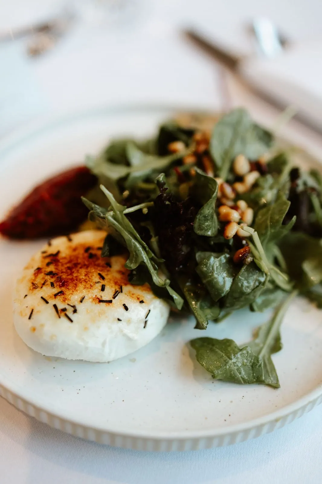 Vorspeise mit gratiniertem Ziegenkäse, Salat und Pinienkernen